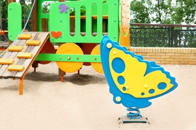 Photo of New butterfly shaped spring rider and colorful train playset on children's playground