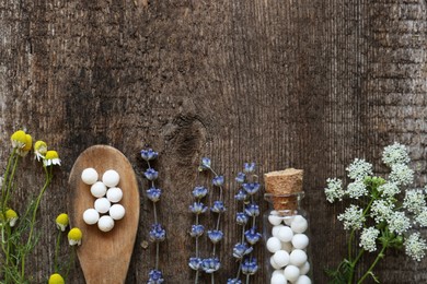Flat lay composition with homeopathic remedy and flowers on wooden table. Space for text