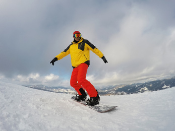 Photo of Man snowboarding at ski resort. Winter vacation