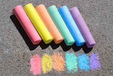 Colorful chalk sticks and strokes on asphalt outdoors, above view