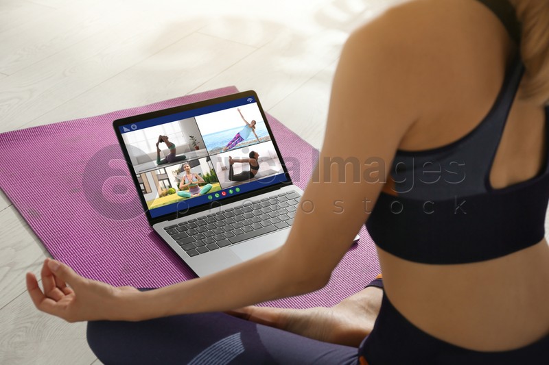 Distance yoga course during coronavirus pandemic. Woman having online video class via laptop at home, closeup 