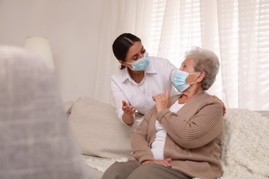 Photo of Doctor taking care of senior woman with protective mask at nursing home