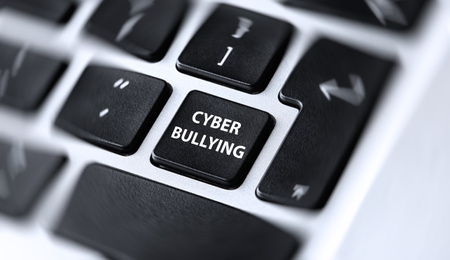 Modern laptop keyboard with phrase CYBER BULLYING on black button, closeup 