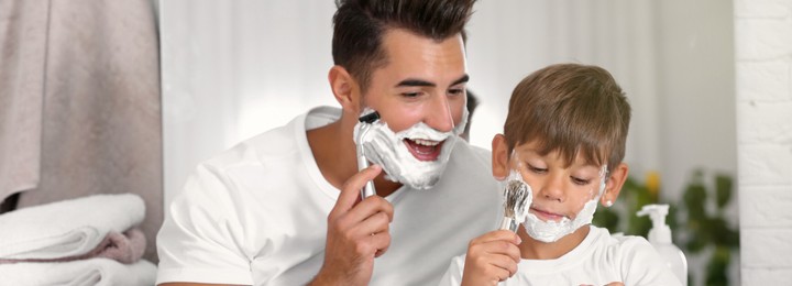 Father and son having fun while shaving in bathroom. Banner design