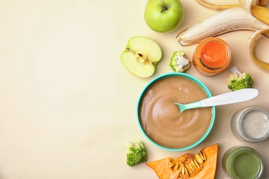 Flat lay composition with bowl of healthy baby food and space for text on color background
