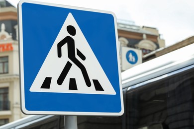 Post with Pedestrian Crossing road sign in city