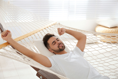 Young man relaxing in hammock at home