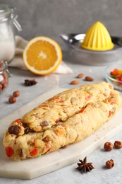 Unbaked Stollen with candied fruits and raisins on light marble table