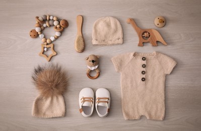 Stylish baby clothes and accessories on wooden background, flat lay