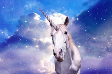 Magic unicorn in fantastic starry sky with fluffy clouds