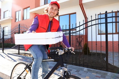 Male courier on bicycle delivering food in city