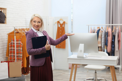 Female business owner with clipboard in boutique