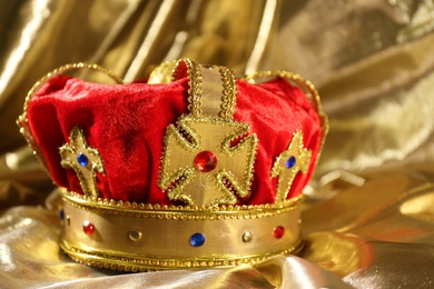 Photo of Beautiful velvet crown on golden fabric. Fantasy item