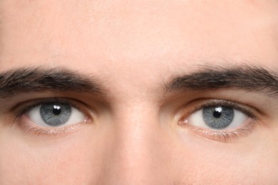 Photo of Closeup view of young man with beautiful grey eyes