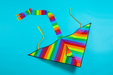 Bright rainbow kite on light blue background, top view