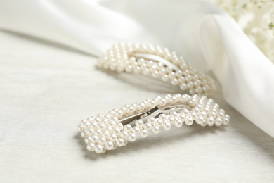Beautiful hair clips with pearls on white table