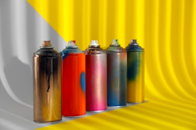 Photo of Used cans of spray paints on color background