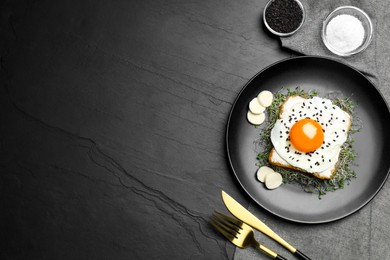 Tasty toast served with egg, cheese and microgreens on black table, top view. Space for text