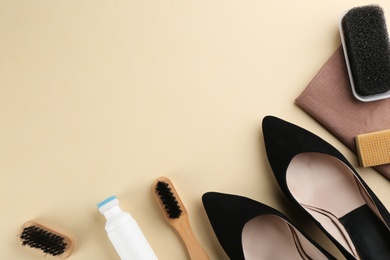 Stylish footwear with shoe care accessories on beige background, flat lay. Space for text