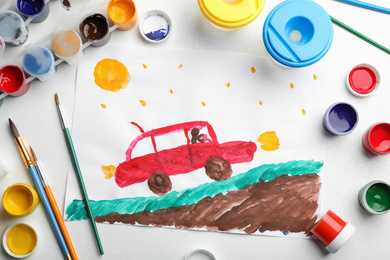Flat lay composition with child's painting of car on white table