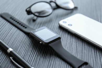 Composition with stylish smart watch on black table, closeup
