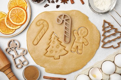 Photo of Christmas treat. Flat lay composition with cookie cutters and dough on light table