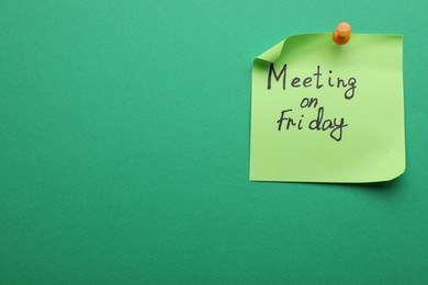 Paper note with words Meeting on Friday pinned to green background, space for text