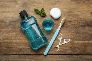Flat lay composition with mouthwash and other oral hygiene products on wooden table