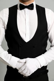 Butler in elegant uniform on grey background, closeup