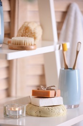 Soap and toiletries on wooden shelves in bathroom