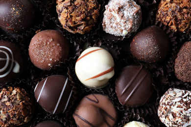 Different tasty chocolate candies as background, top view