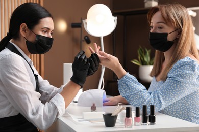 Professional manicurist working with client in salon. Beauty services during Coronavirus quarantine