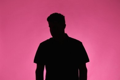 Silhouette of anonymous man on pink background