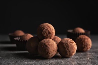Tasty raw chocolate truffles on grey table