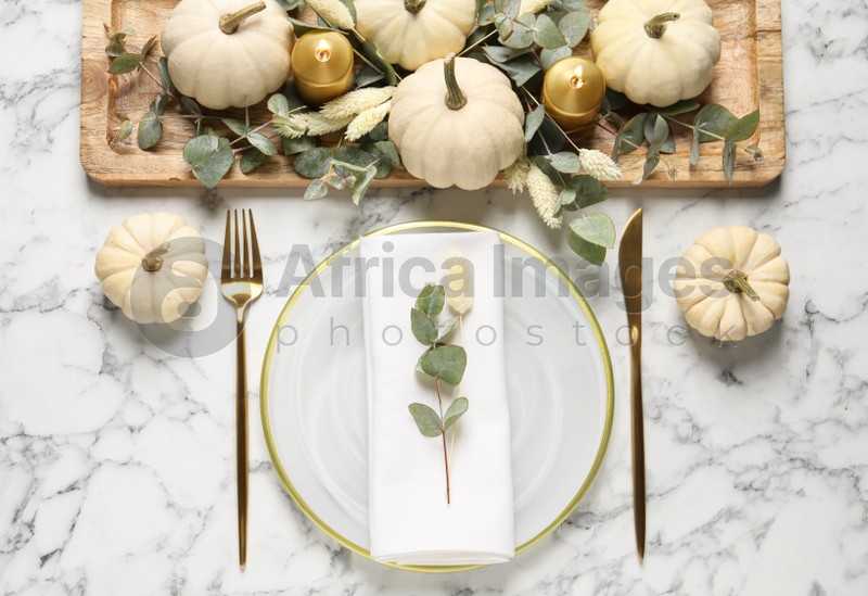 Festive table setting with autumn decor on white marble background, flat lay