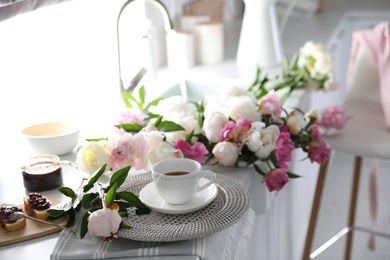 Beautiful peonies and breakfast on kitchen counter