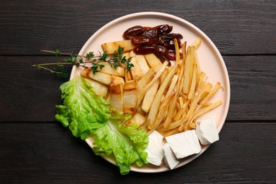 Photo of Delicious parsnip with lettuce, feta cheese and dates on black wooden table, top view