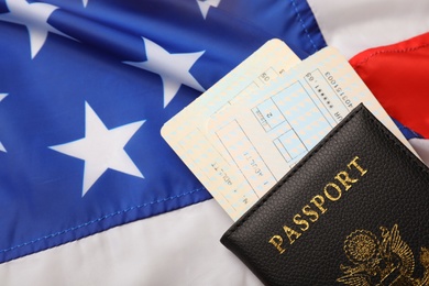 Passport and tickets on flag of USA, top view