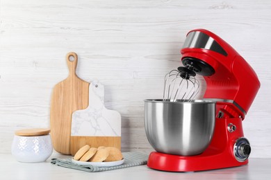 Photo of Modern red stand mixer and cookies on white marble table