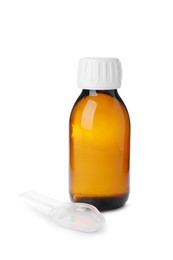 Photo of Bottle of syrup with plastic spoon on white background. Cough and cold medicine