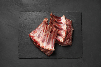 Photo of Raw ribs on black table, top view