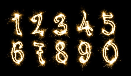 Image of Set with numbers silhouettes made of sparkler on black background