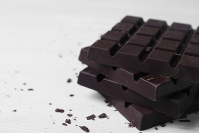 Tasty dark chocolate bars on white table, closeup
