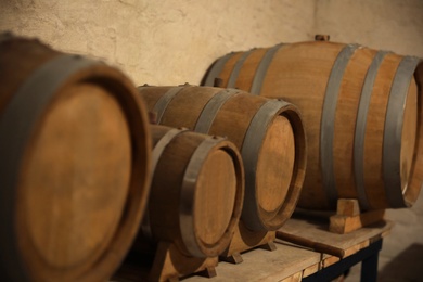 Different wooden barrels on table in wine cellar