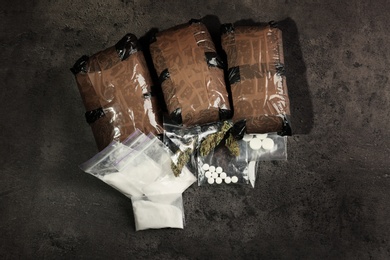 Composition with hemp in packages on grey  background, top view
