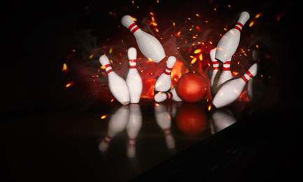 Bowling ball bouncing pins with fire. Successful hit - strike