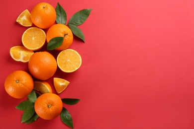 Delicious oranges on red background, flat lay. Space for text