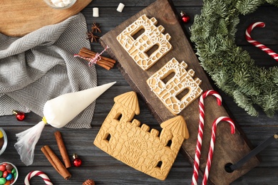 Flat lay composition with parts of gingerbread parts on black wooden table