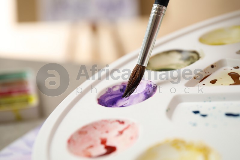 Brush and palette with watercolor paints, closeup