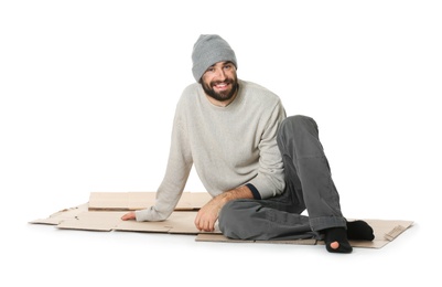 Poor homeless man sitting on cardboard, white background